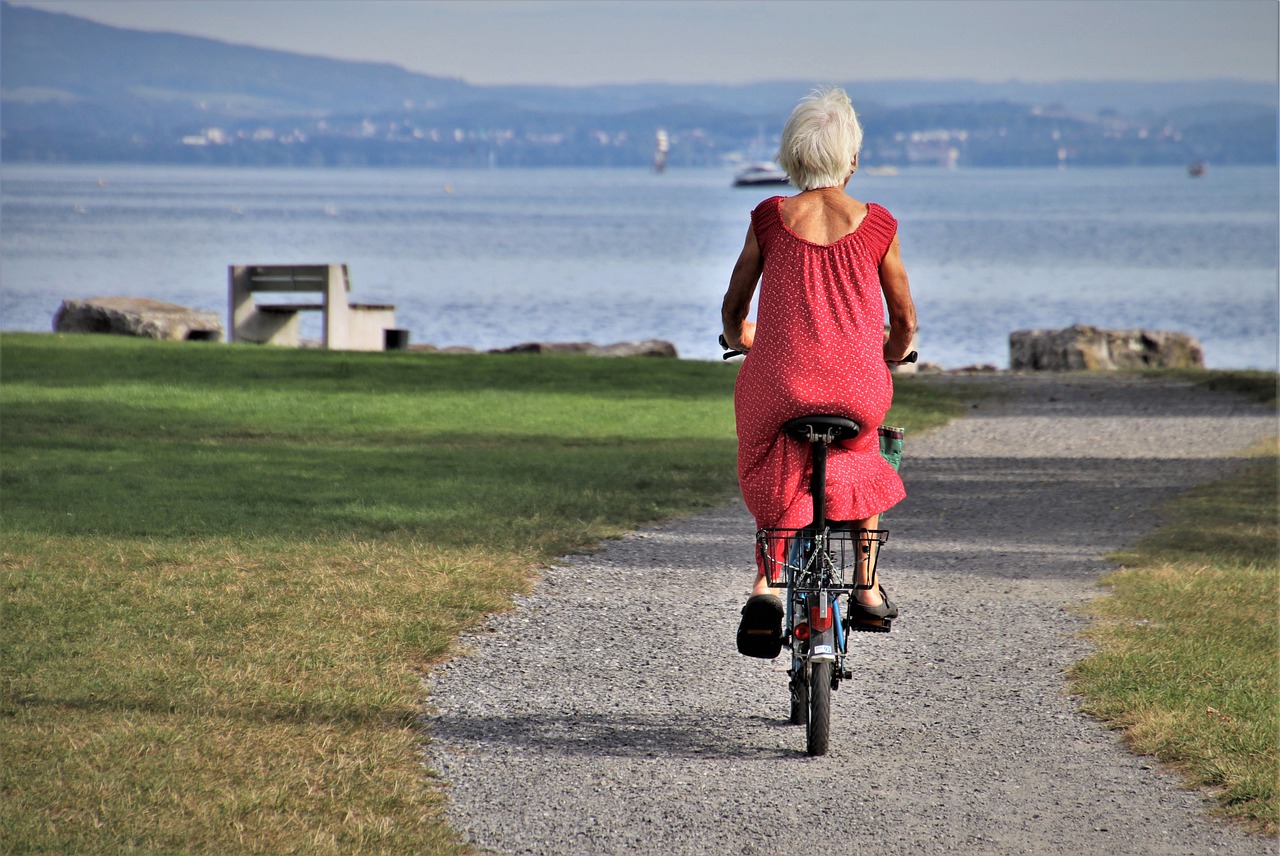 Photo d'une senior faisant du vélo face à la mer
