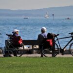 couple de seniors assis sur un banc devant la mer, ils font une pause lors d'une ballade à vélo