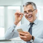 Photo d'un homme en costume avec des lunettes, il sourie ; représentant un cadre propriétaire heureux